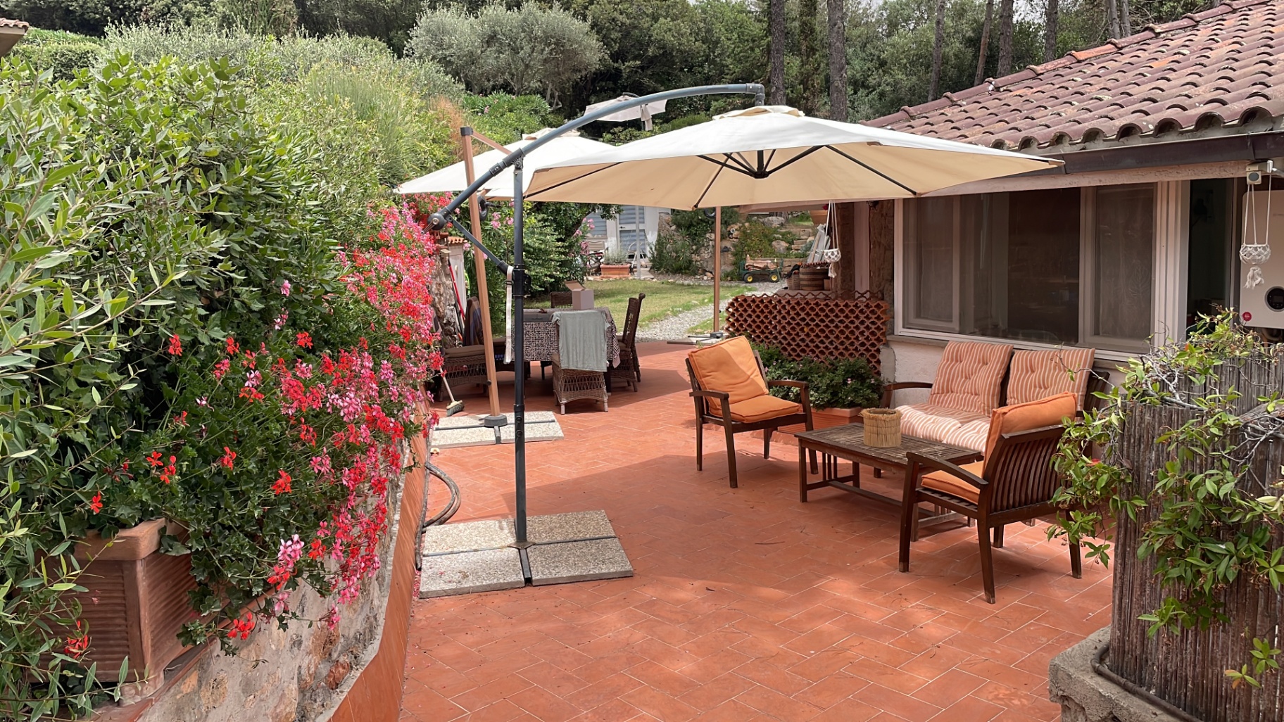Patio with cantilever umbrella and geraniums